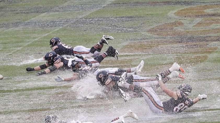 Bears vs Packers featured image of players sliding through a wet Soldier Field.
