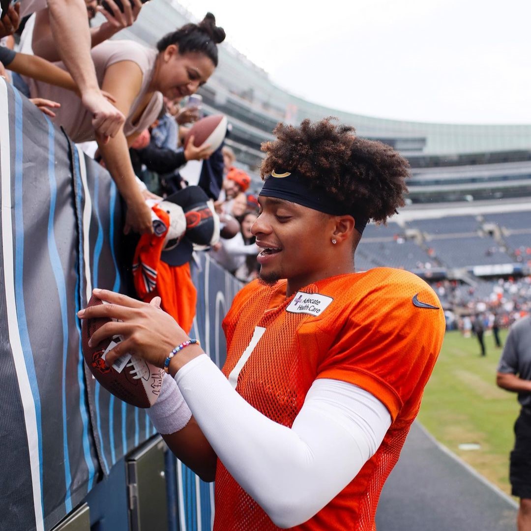 2023 Fantasy Football post featured image of Bear's QB Justin Fields autographing a fan's football.