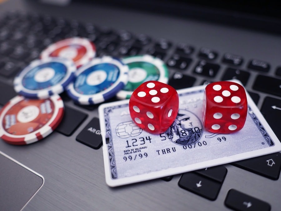 Online Casino Bonuses, poker chips, dice, credit card on laptop