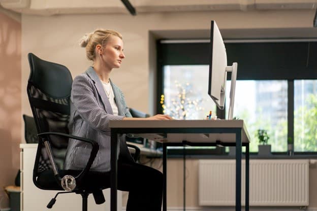 Woman sitting on Ergonomic chair in office