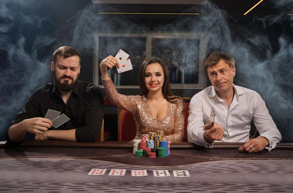 3 people sitting at a poker table