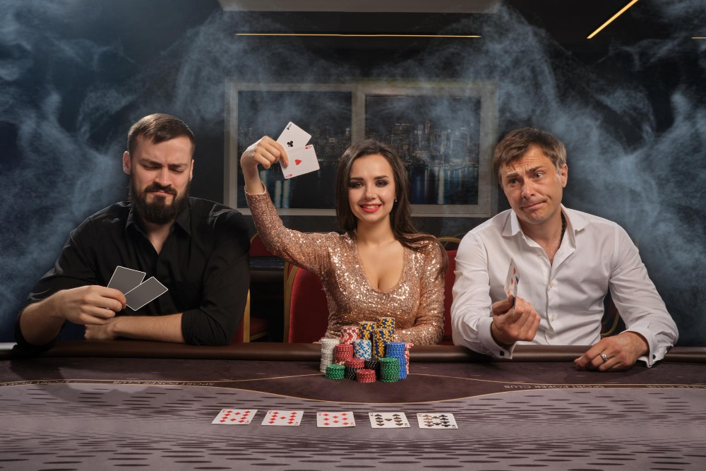 3 people sitting at a poker table