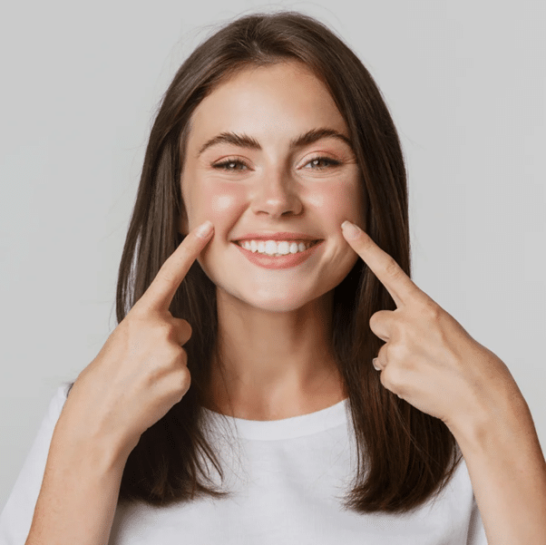 Woman smiling and pointing her fingers at her smile