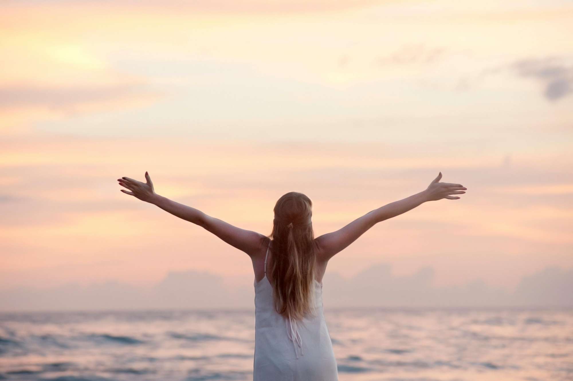 Woman at ocean enjoying the sunset