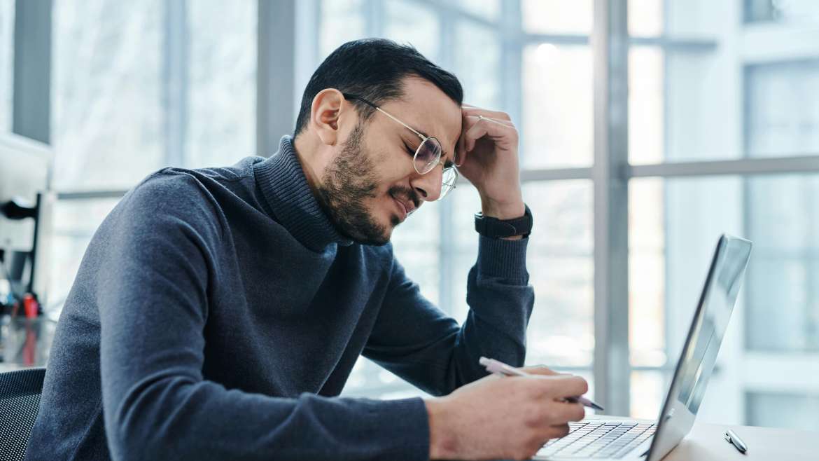 Man with back pain sitting at a table