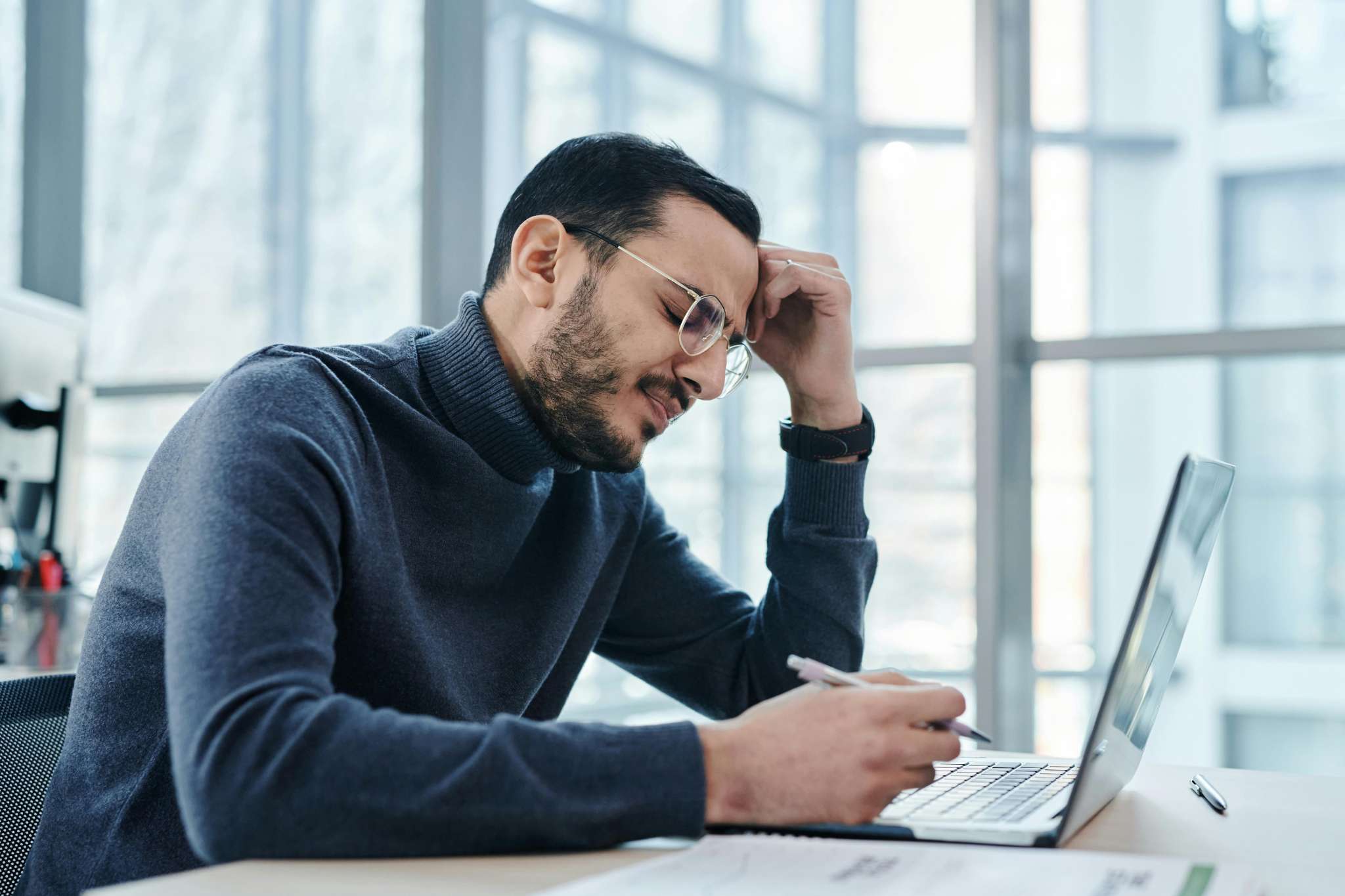 Man with back pain sitting at a table