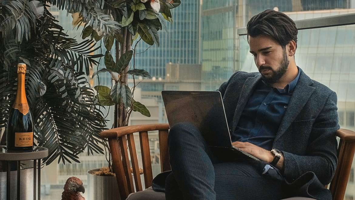 Man sitting in chair with laptop on his lap