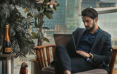 Man sitting in chair with laptop on his lap