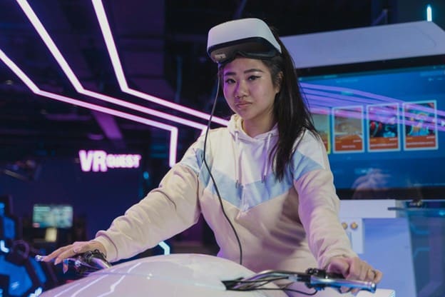 Girl with VR Glasses on a bike in a game center