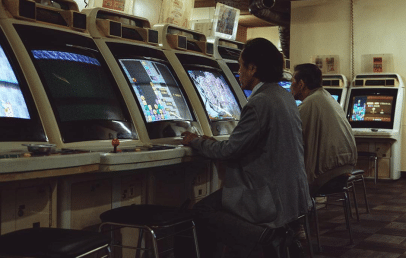 Man in a public gaming hall in front of a computer