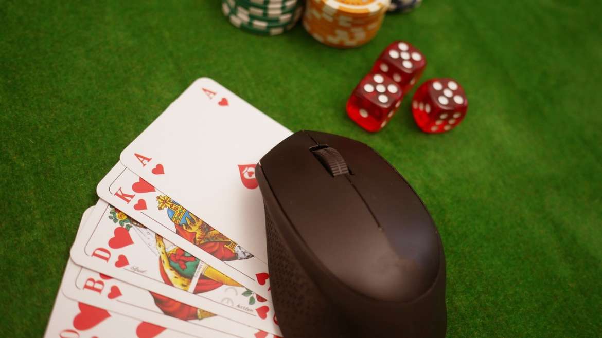 Computer mouse on poker table with poker chips and cards