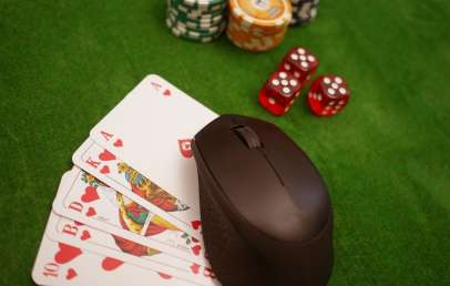 Computer mouse on poker table with poker chips and cards
