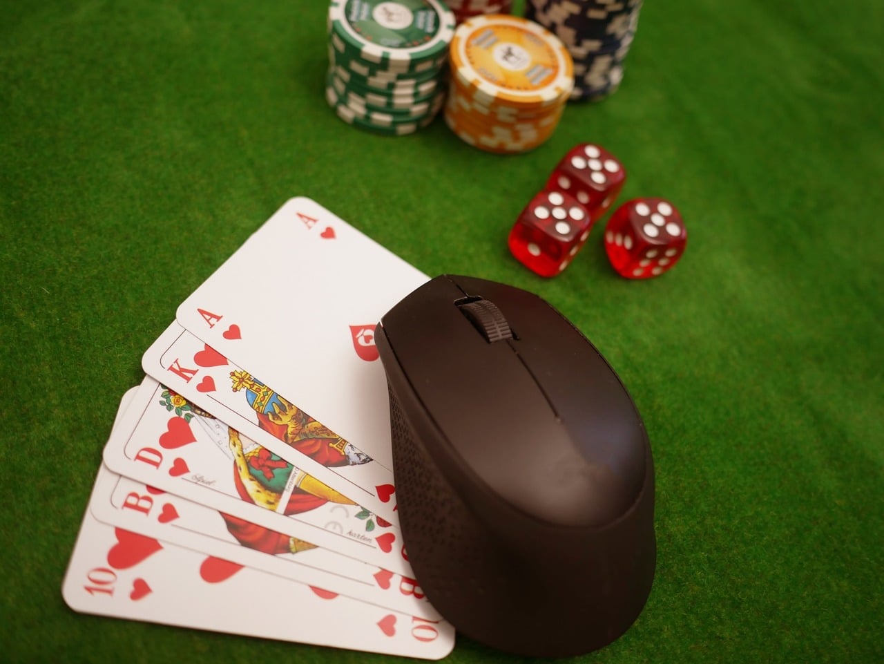 Computer mouse on poker table with poker chips and cards