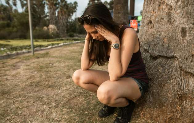 Woman leaning on tree stressful position