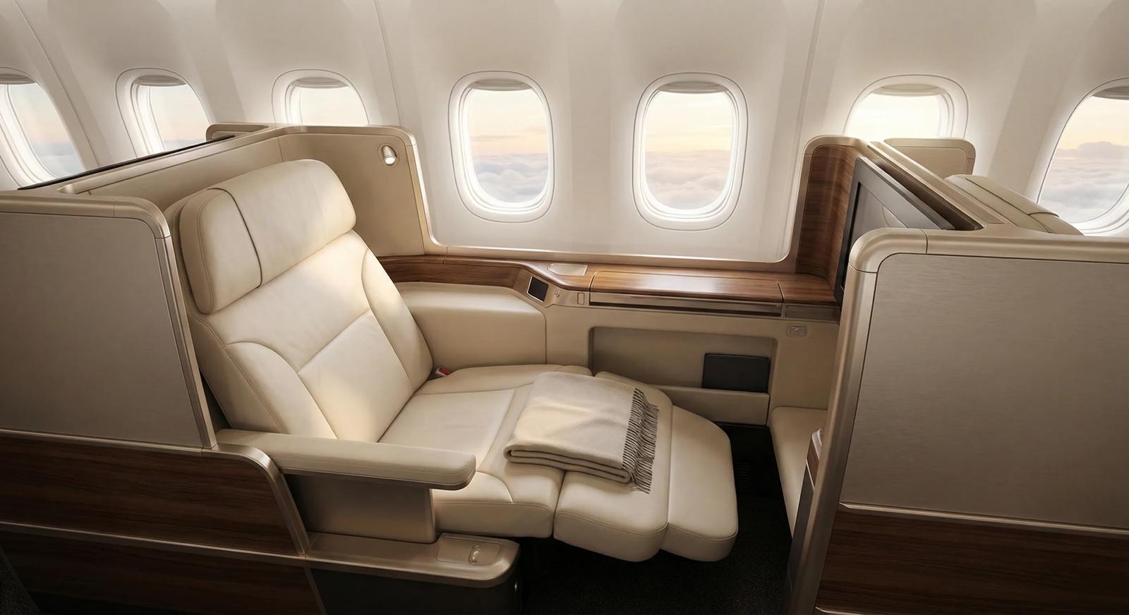 Wide-angle view of a spacious, modern business-class cabin suite with natural light, highlighting luxury travel comfort