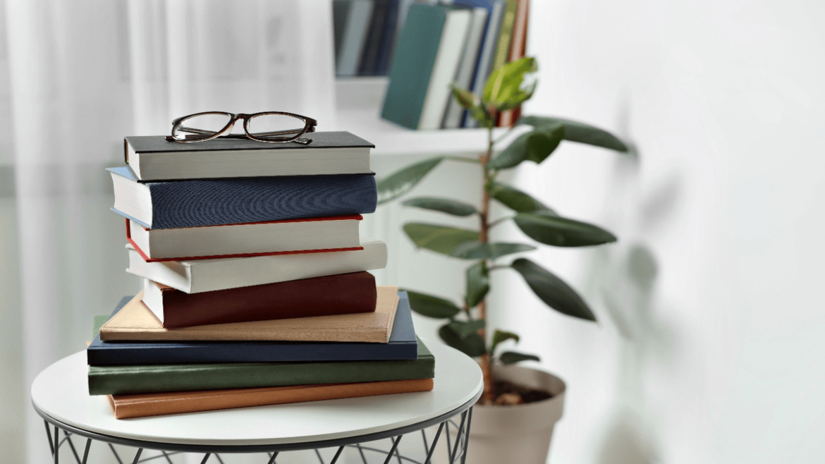 Stack of books with glasses on a table representing recommended reading on South Korea–Japan tensions, including history, politics, and alternative perspectives